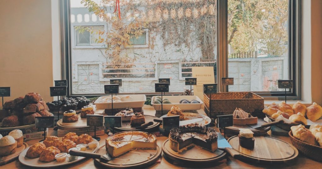 A table filled with lots of food next to a window