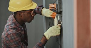 man in brown hat holding black and gray power tool