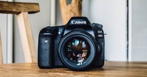 Canon DSLR camera on brown wooden table during daytime