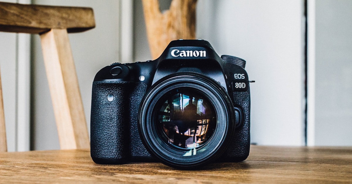 Canon DSLR camera on brown wooden table during daytime