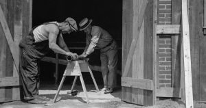 a couple of men working on a wooden structure