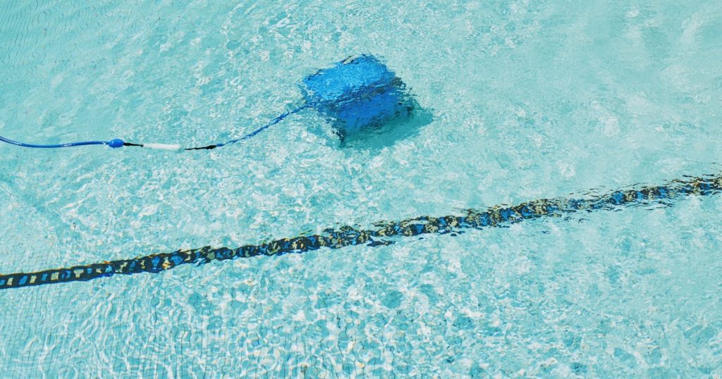 A robotic pool cleaner is working underwater.