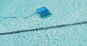 A robotic pool cleaner is working underwater.