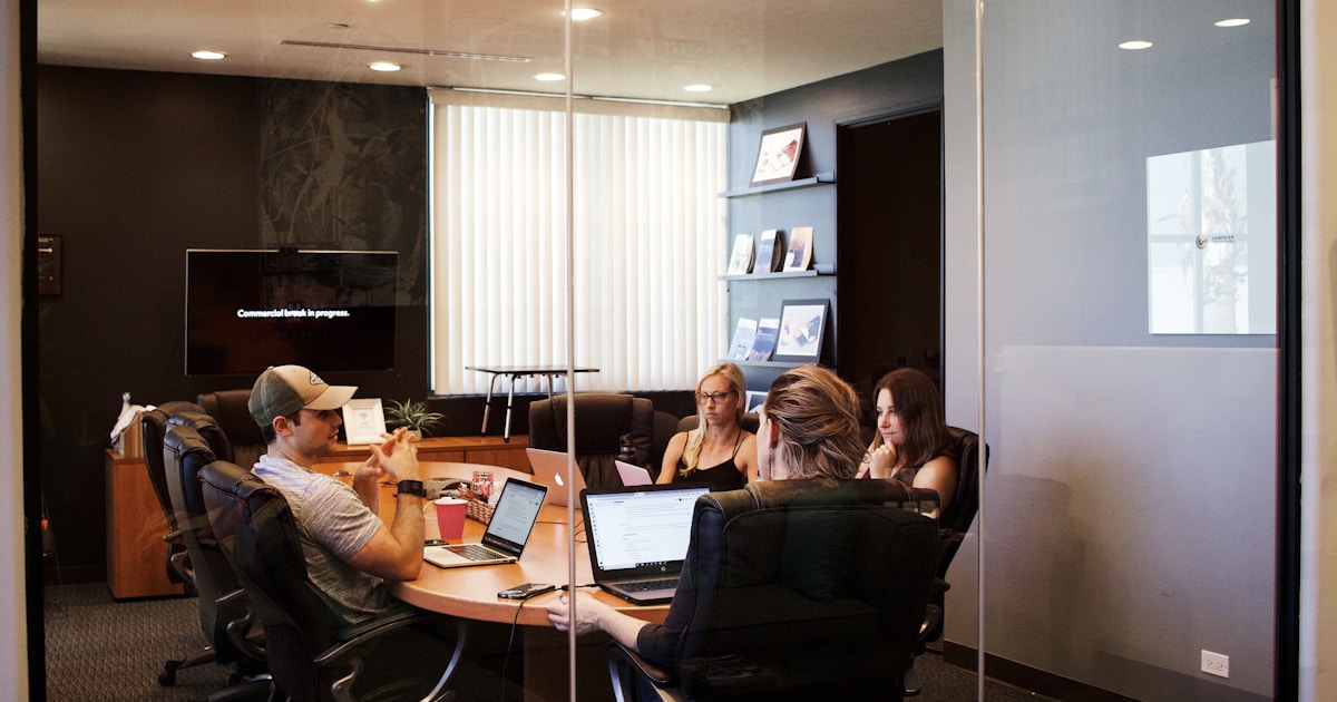 people sitting near table with laptop computer