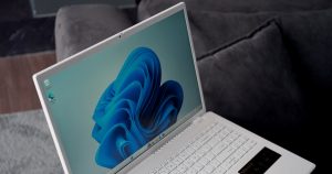 A white laptop with a blue windows 11 wallpaper.