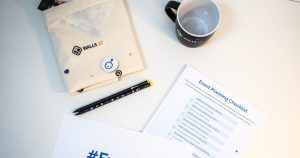 a table with a coffee cup, notepad, pen, and envelope