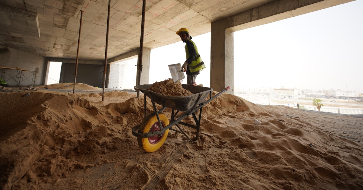a construction worker standing in a pile of sand