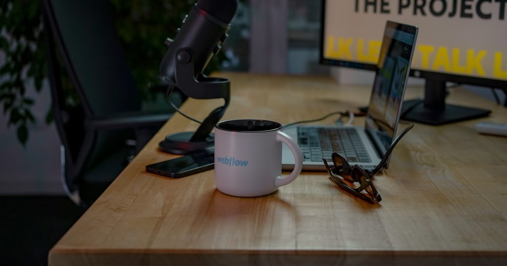 a desk with a laptop and a coffee mug on it