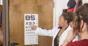 a woman pointing at a sign on a door