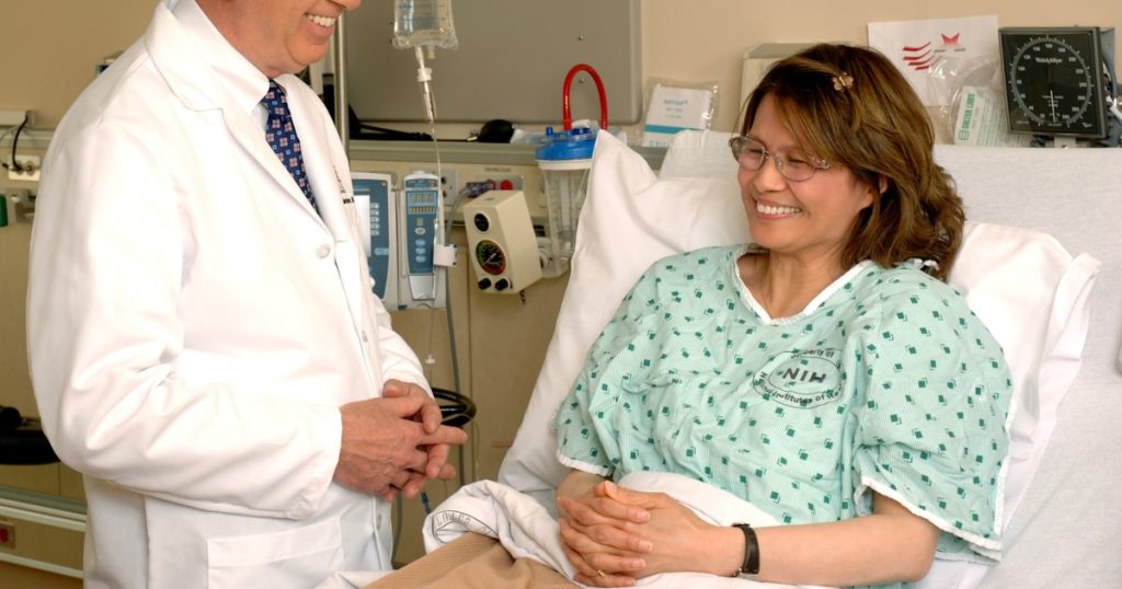 woman in teal scrub suit sitting beside man in white medical scrub suit