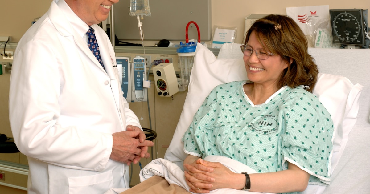 woman in teal scrub suit sitting beside man in white medical scrub suit