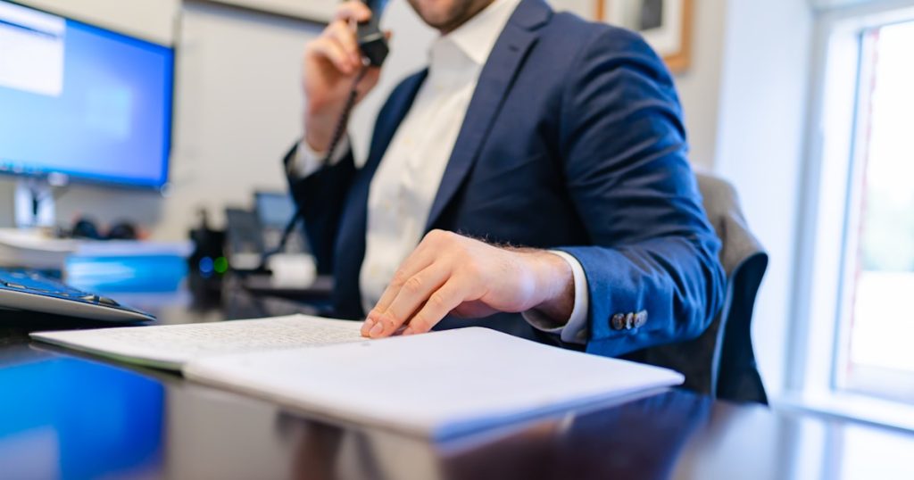 a man sitting at a desk writing on a piece of paper