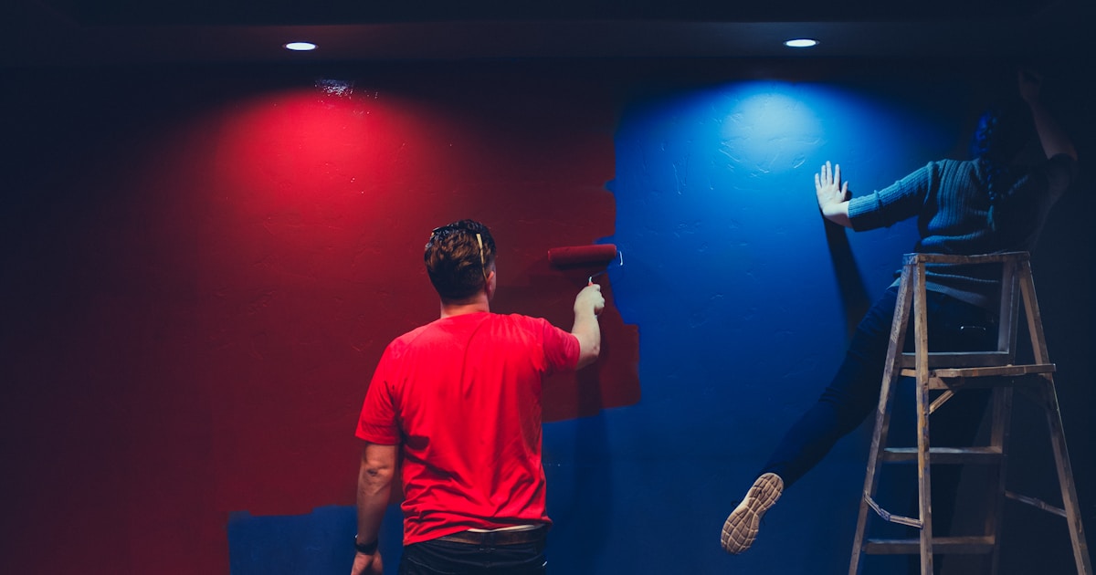 man and woman painting wall
