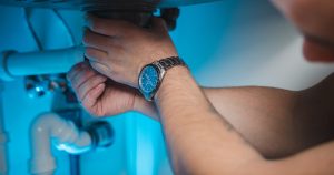 a man fixing a water heater in a room