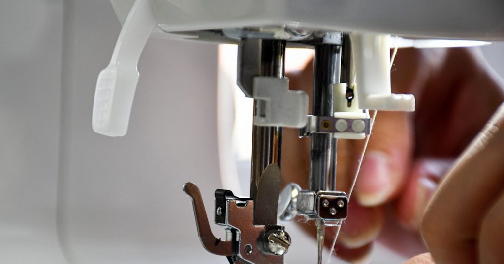 person using sewing machine in tilt shift lens