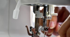 person using sewing machine in tilt shift lens
