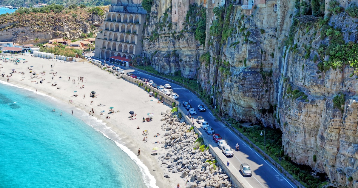 people standing and lying on beach during daytime