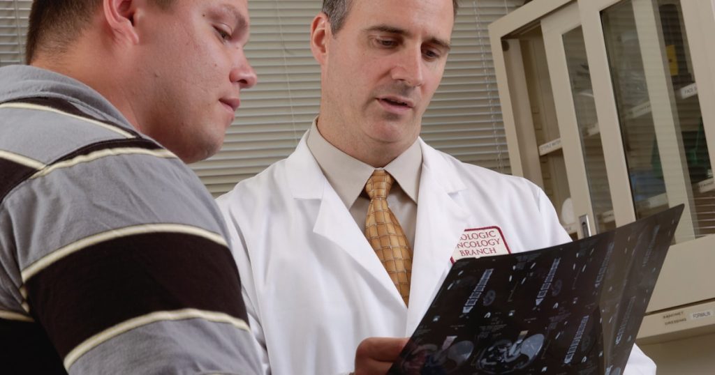 man in white dress shirt holding black tablet computer