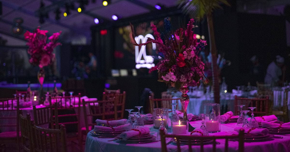 a table set up for a party with candles and flowers
