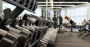 woman standing surrounded by exercise equipment