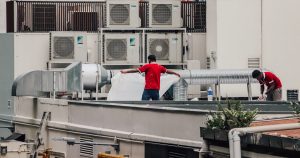 a couple of men standing on top of a roof