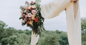 bouquet of assorted-color flowers hanged on brown plank with white textile