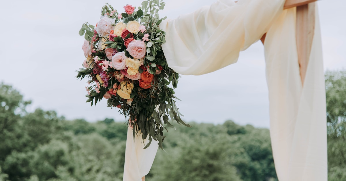 bouquet of assorted-color flowers hanged on brown plank with white textile