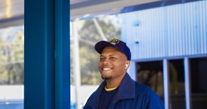 A man in a blue uniform standing in front of a building