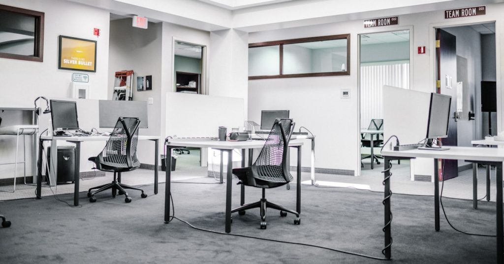 black metal chairs and table near white wall