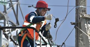 a man in safety gear working on a power pole