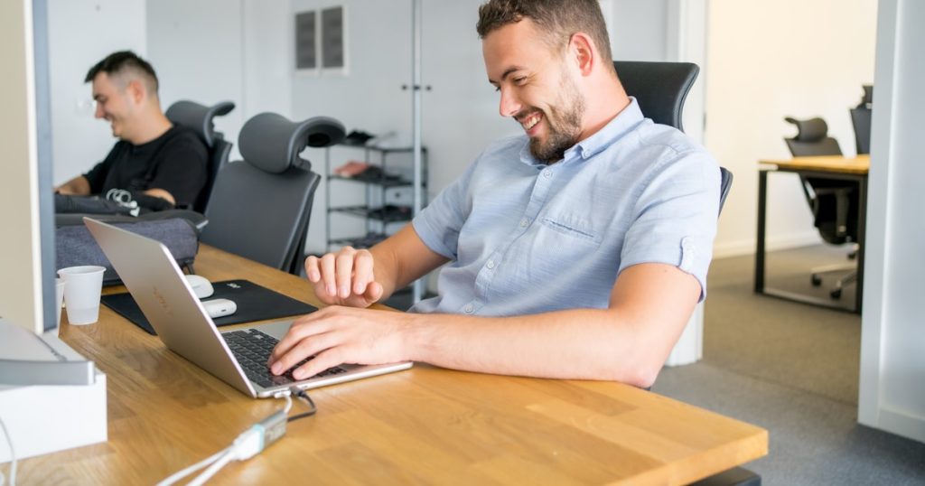 a man sitting in front of a laptop computer