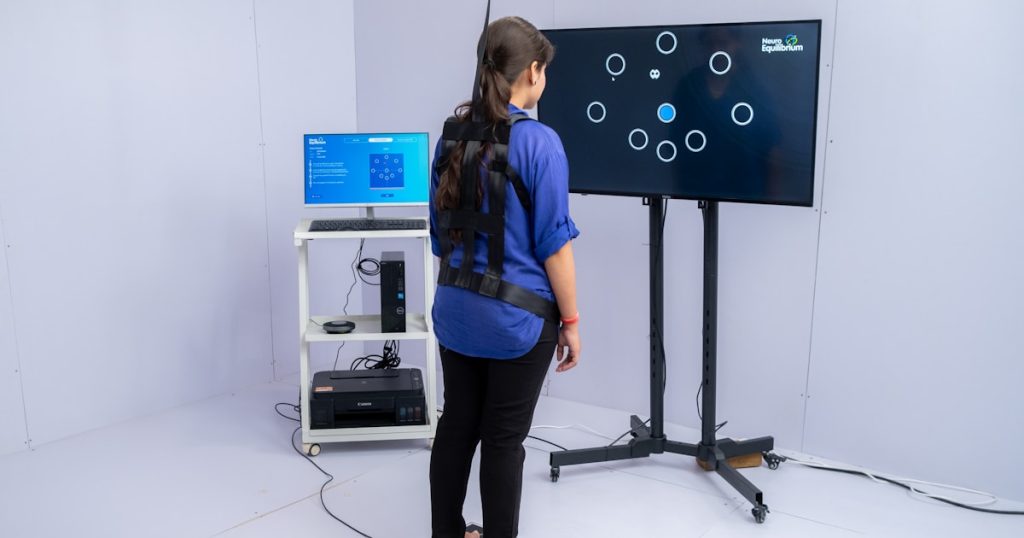 Woman stands on pressure plate with sensors on-screen interactive game.