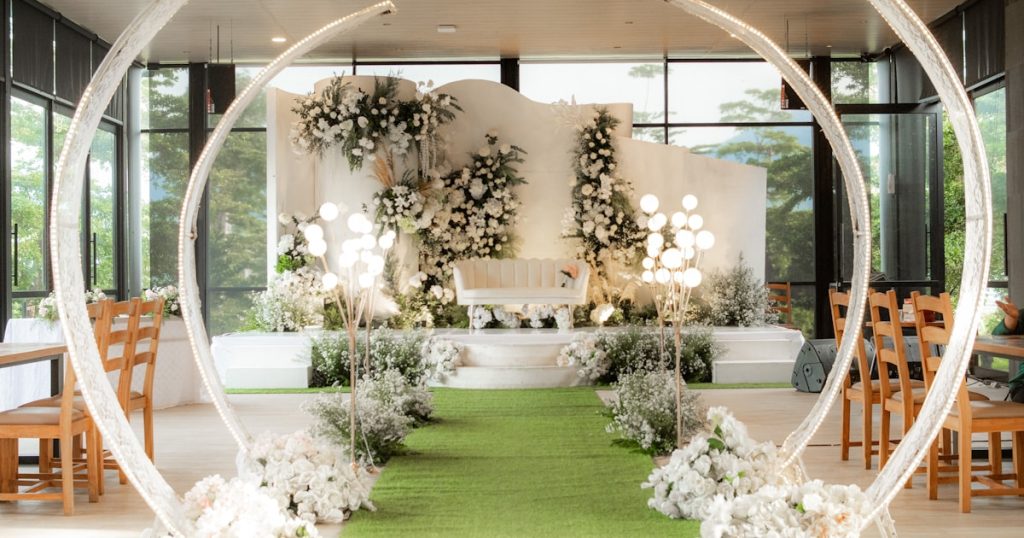 A wedding ceremony with a green carpet and white flowers