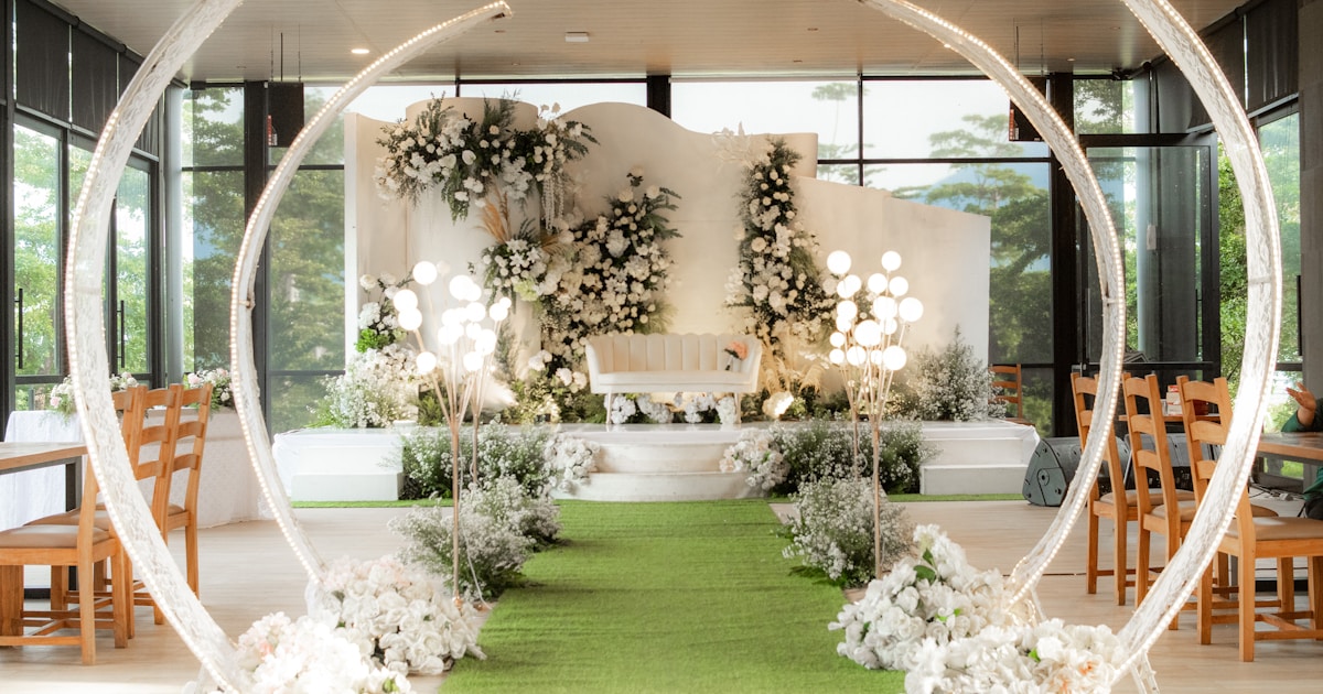 A wedding ceremony with a green carpet and white flowers