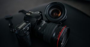 black Canon DSLR camera beside camera lens