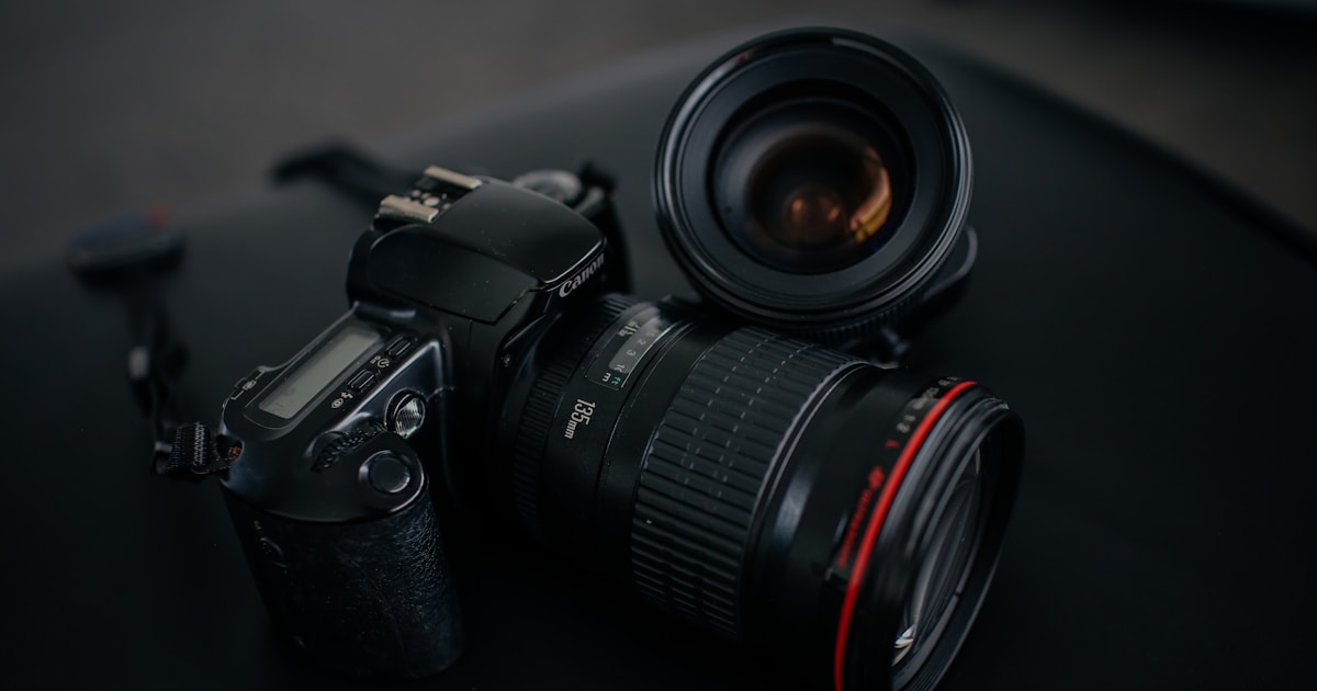 black Canon DSLR camera beside camera lens