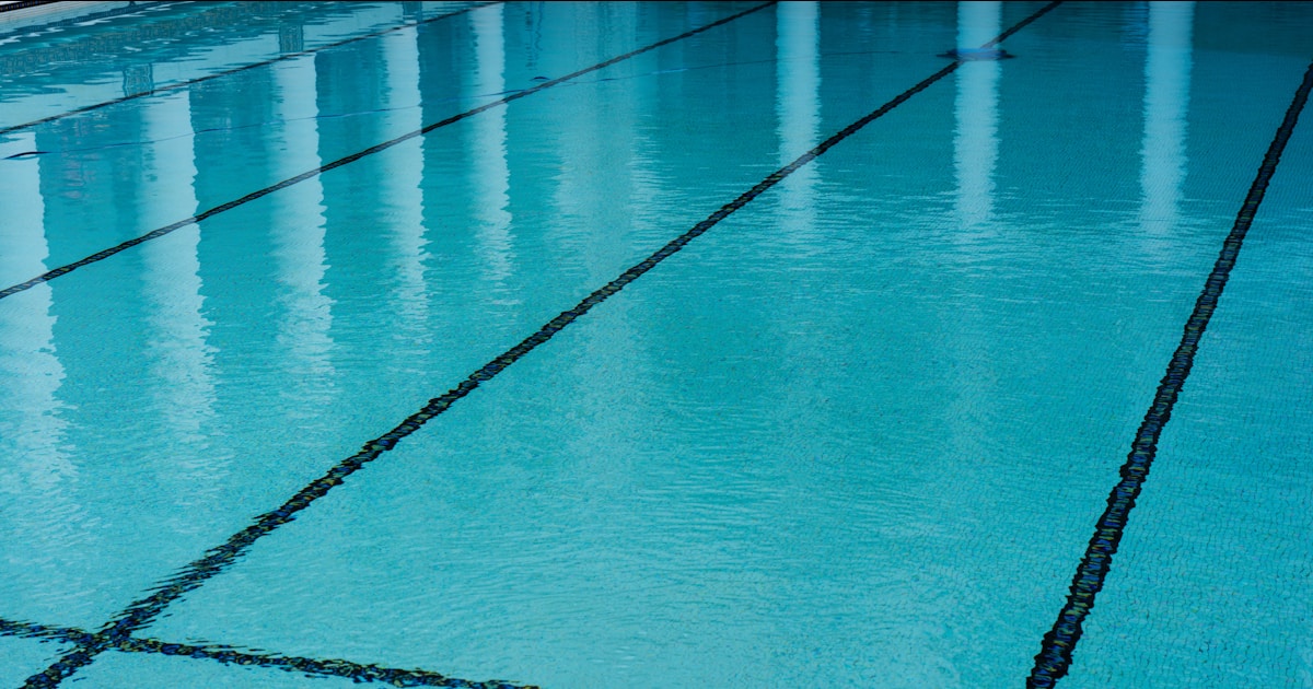 A swimming pool with a tiled floor and blue water