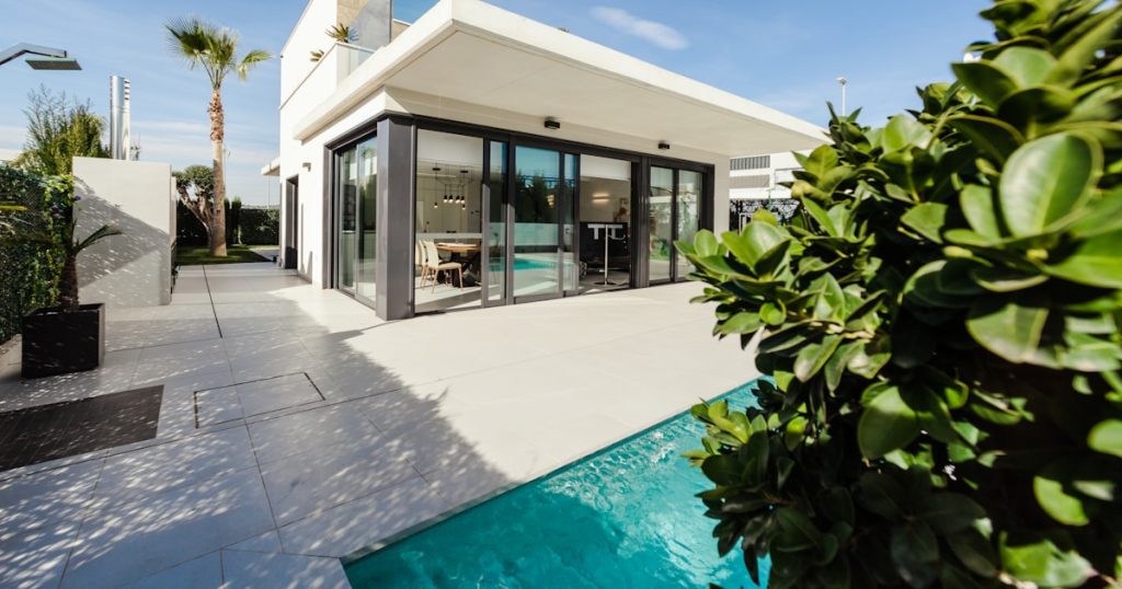 white and grey concrete building near swimming pool under clear sky during daytime