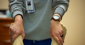 A nurse is performing physical therapy.