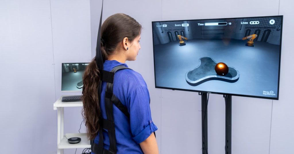 Woman wearing harness interacts with virtual reality game.