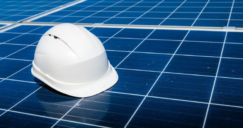 a white hard hat sitting on top of a solar panel