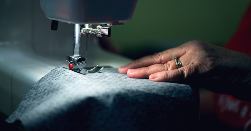 person in gray shirt sewing