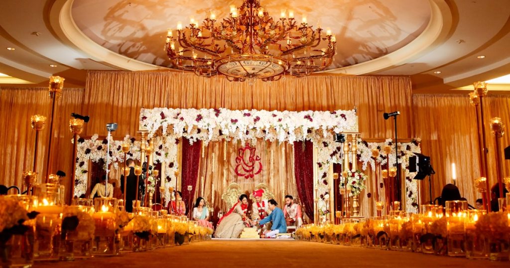 people standing in gold and white floral ceiling